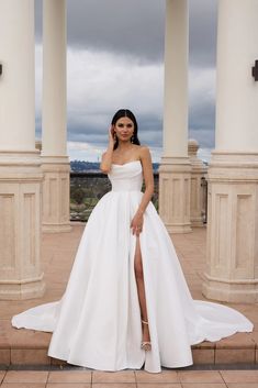 a woman in a white wedding dress posing for the camera