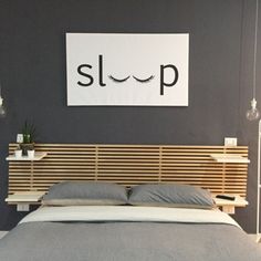 a bed that has a wooden headboard on top of it and a sign above it