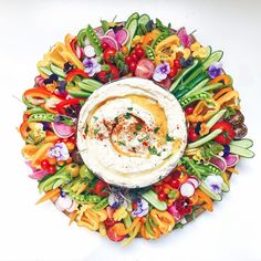 an arrangement of vegetables and dip in a bowl