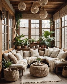 a living room filled with lots of furniture and potted plants on the windowsill