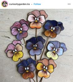 a bunch of flowers sitting on top of a cement floor in front of a wall