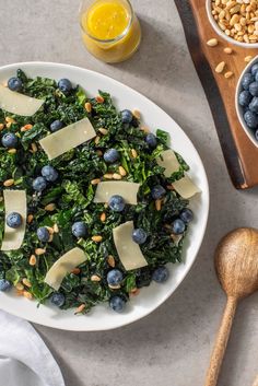 a white plate topped with greens and blueberries