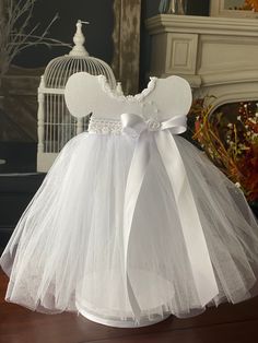 "This dress are ideal for Blessed Baby Girl, First Communion, Birthday party, Baby Shower and more The dress flows beautifully with White tulle and is accented with soft White satin bows and is finished with a trim around the neckline YOU WILL RECEIVE ONE TUTU DRESS CENTERPIECE Elegant White Tutu Dress Centerpiece Double sided 14\" tall 7\" wide Please allow 1-2 weeks processing when ordering. If you let me know your party date, I will ship your order so it arrives about a week before your event Dress Centerpiece, White Tutu Dress, Tutu Centerpieces, Communion Centerpieces, Blessed Girl, Girl Baby Shower Centerpieces, Tutu Baby Shower, First Communion Decorations, Communion Decorations