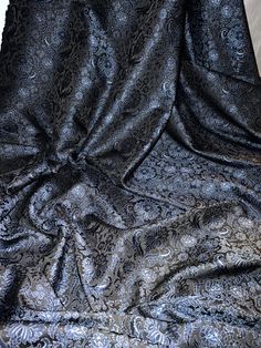 an image of a black and silver cloth on the floor with it's folds