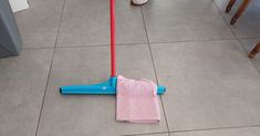 a pink and blue mop sitting on top of a tile floor