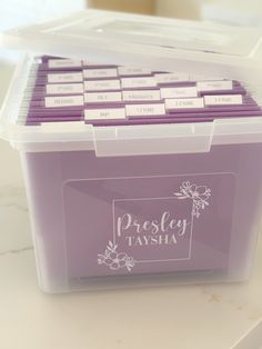 a plastic container filled with purple labels on top of a table