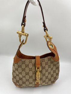 A stunning vintage Gucci Jackie bag made from beige canvas with tan leather trim and chunky gold hardware. This bag also has the iconic Gucci pin lock closure. Inside the bag is lined with a brown cotton lining and there is a zipped pocket for valuables. This bag is in very good vintage condition, there are some minor marks to the hardware and some minor signs of wear to the leather corners on base. A true collectors item and comes with its original Gucci dust bag. Vintage Gucci Jackie, Pin Lock, Diaper Backpack, Casual Backpack, Baby Bag, Handbag Backpack, Leather Trim, Gucci Jackie Bag, Vintage Gucci