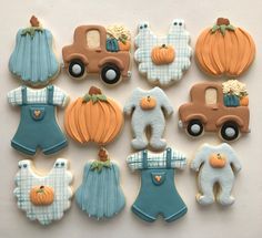 many decorated cookies in the shape of pumpkins and baby ones