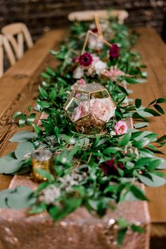 a long table with flowers and greenery on it