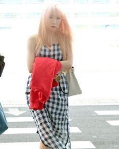 a woman with pink hair is walking down the street