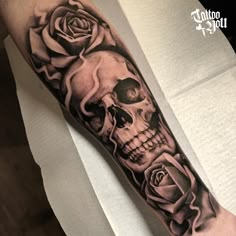 a man with a skull and roses tattoo on his arm