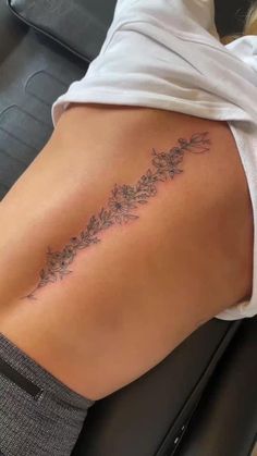 a woman's lower back tattoo with flowers on it