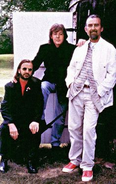 two men and one woman are posing for a photo