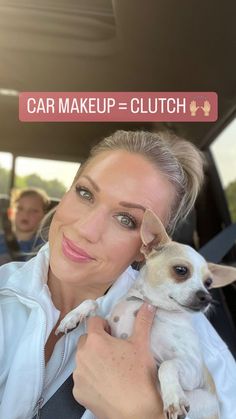 a woman holding a small dog in her lap while sitting in the back of a car