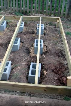 an outdoor garden with cinder blocks in the ground