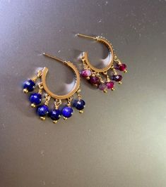 14K gold plated Hoop-looking earrings that are worn like any earring with a post. Earrings are 22mm in diameter which is neither too small nor too big for everyday wear. All Natural semiprecious stone beads. Pictures show pink Tourmaline and Lapis Lazuli stone earrings. There are more stone choices in options to choose from. If you have any specific stone in mind please reach out to me and I may be able to accommodate. Round Gemstone Beads Hoop Earrings As Gift, Gold Earrings With Colorful Beads, Elegant Gold Hoop Earrings With Colorful Beads, Small Hoop Earrings With Dangling Beads As Gift, Gemstone Beads Hoop Earrings Gift, Gold Earrings With Gemstone Beads, Beaded 14k Gold Filled Round Earrings, Gold Dangle Earrings With Gemstone Beads, 14k Gold Filled Beaded Round Earrings