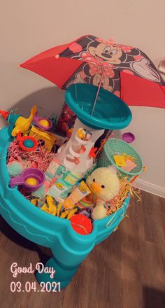 a blue toy boat filled with toys and an umbrella