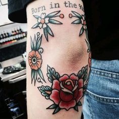 a person with a rose tattoo on their arm and the words born in the sun