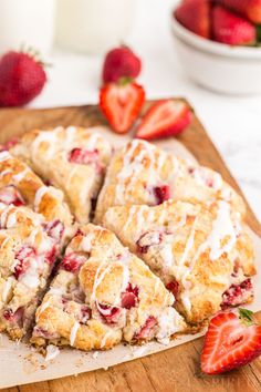 strawberry scones with icing and strawberries on a cutting board