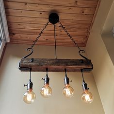 three light fixtures hanging from a wooden beam