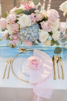 a white table topped with pink and blue flowers