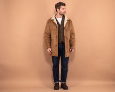 A faux sheepskin coat from the late 90's featuring a front button closure, a notched collar, two outer pockets, and one smaller zip pocket inside. While resembling a sheepskin appearance this coat is crafted from 100% polyester materials thus being a cruelty-free alternative to the classic sheepskin coat. Vintage condition level: 7/10. Showing some wear and discoloration, more visibly around the pockets and arm sleeves/elbows. Model Raitis is 6 ft (180 cm), 191 lbs (87 kg) and he wears the size Faux Shearling Coat, Level 7, Sherpa Coat, Sheepskin Coat, Coat Vintage, Sherpa Jacket, Cow Boy, Shearling Coat, Vintage Coat