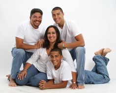 a group of people sitting next to each other posing for a photo with their arms around one another