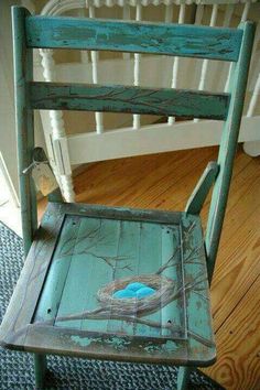 an old chair with a bird painted on it