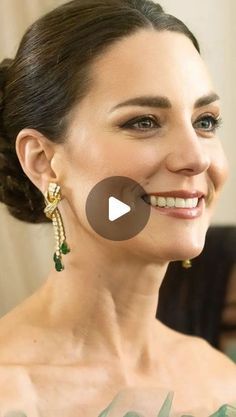 a woman with tattoos on her chest smiling and looking at the camera while wearing green earrings