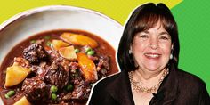 a woman standing next to a bowl of stew and a plate of food on the table