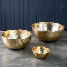 three gold bowls sitting on top of a table