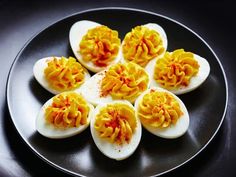 deviled eggs are arranged on a black plate