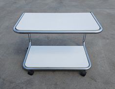 a white table sitting on top of a cement floor