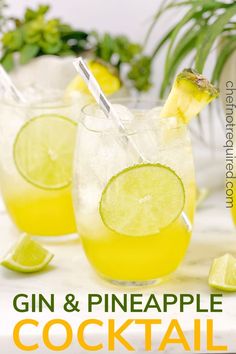 two glasses filled with gin and pineapple cocktail next to limes on a table