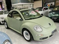 a green car is parked in a showroom