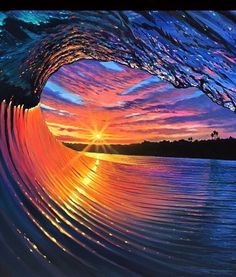 the sun is setting behind a large wave in the ocean with water swirling around it