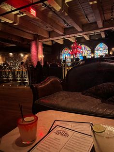 a table with drinks and menus in front of stained glass windows at a bar