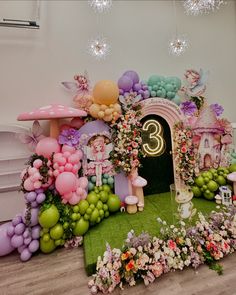 a room decorated with balloons, flowers and fairy land decorations for a birthday or baby's first birthday