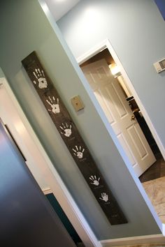 two wall hangings with paw prints on them in a hallway next to a door