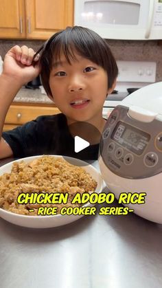 a young boy sitting in front of a bowl of rice next to an air fryer