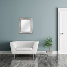 a living room with blue walls, white furniture and a potted plant in the corner