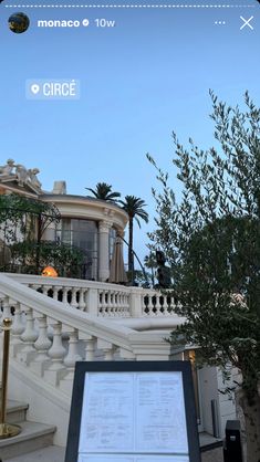 an image of a house with stairs and trees in the foreground, taken on a cell phone