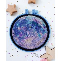 a cross stitch project with stars on it and a wooden star decoration next to it