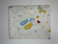 a baby blanket with teddy bears on it and a balloon flying in the sky above