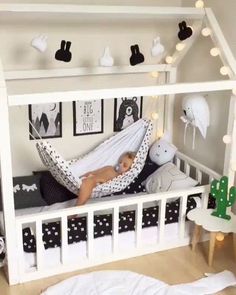 a baby is sleeping in a white crib with black and white decorations on the walls