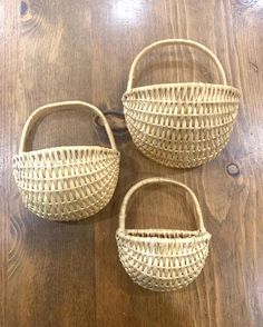 three woven baskets sitting on top of a wooden floor