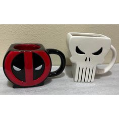 two mugs one with a skull and the other with a spiderman face on them