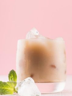 a drink with ice cubes and mint on the side