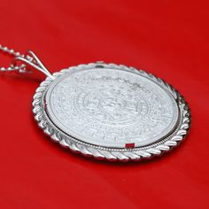 "A gorgeous sterling silver necklace, set with an authentic Mexico 1 oz Silver Round BU Uncirculated Coin - Aztec Calendar. Obverse: Depicts the famous Aztec Calendar stone. The design is in a circular shape resembling a sun, with rays emanating outward. In the center is the face of the Aztec solar deity, Tonatiuh, which gives the monolith its alternate name the Sun Stone. Reverse: depicts the striking left portrait of Cuauhtemoc, the last Aztec Emperor of Tenochtitlan. The name Cuauhtemoc means Uncirculated Coins, Silver Coin Necklace, Half Dollar Coin, Aztec Calendar, Coin Jewelry, Silver Coins, Beautiful Gift Boxes, Solid 925 Sterling Silver, Sterling Silver Necklaces