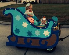 two children in a blue and brown sleigh